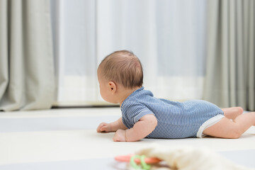 Fototapeta premium Newborn baby lying on floor lifting head