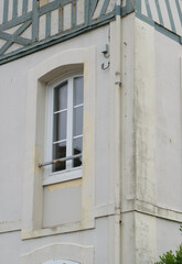 Window of a coastal old house in a seaside town setting under a cloudy sky during late afternoon hours
