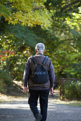 Obraz premium 秋の朝の公園で散歩するシニア男性の姿