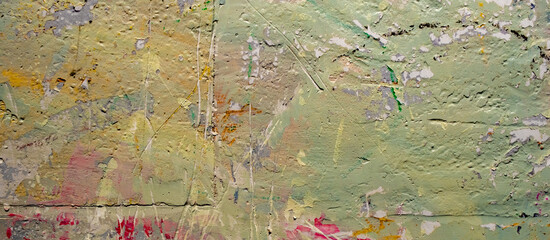 a textured, weathered wall with a chaotic mix of colors and textures.  The surface is heavily textured, showing signs of age and wear, with visible cracks and layers of paint