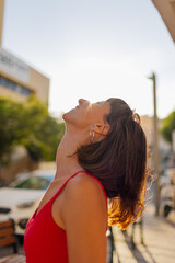 A calm girl rests in the middle of the city, surrounded by houses and cars.