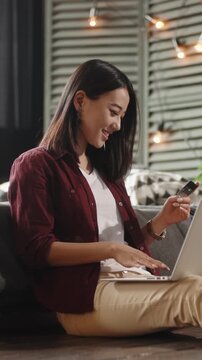 slow motion vertical asian woman paying online with credit card laptop e commerce shopping smart money finance freedom fintech home lifestyle happiness digital world