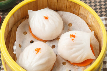 Cantonese shrimp dumplings, served in a steamer basket, were arranged on a tablecloth.