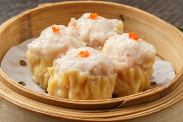 Cantonese shrimp dumplings, served in a steamer basket, were arranged on a tablecloth.