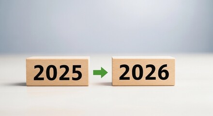 Wooden blocks with the numbers 2025 and 2026 and an arrow indicating the transition to the new year.