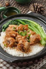 Fototapeta premium A black clay pot of cordyceps flower and pork rib congee was placed on a tablecloth.