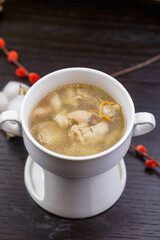 Cordyceps flower and pig's trotter soup served in a white porcelain soup bowl