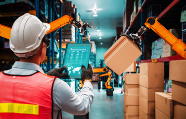 Fototapeta premium Smart robot arm systems for innovative warehouse and factory digital technology . Automation manufacturing robot controlled by industry engineering using IOT software connected to internet network .