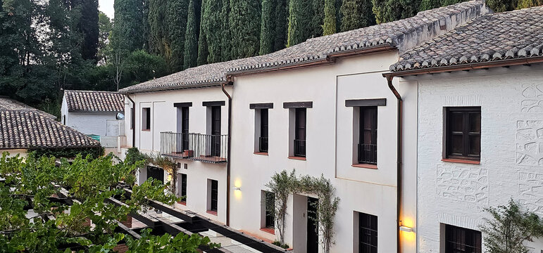 Arquitectura tradicional andaluza con fachadas blancas y tejados de tejas en los montes del Albaic&iacute;n, rodeados de vegetaci&oacute;n y cipreses. arquitectura, entorno