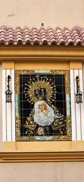 Panel cer&aacute;mico devocional de la Virgen Mar&iacute;a en una fachada del Albaic&iacute;n, enmarcado con faroles y detalles andaluces. religi&oacute;n, tradici&oacute;n