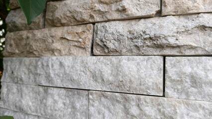 This photo features a textured stone wall with natural colors and rough surfaces, perfect for use as a background, architectural design element, website banner, or construction-themed visual.