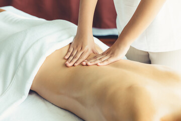 Caucasian woman customer enjoying relaxing anti-stress spa massage and pampering with beauty skin recreation leisure in day light ambient salon spa at luxury resort or hotel. Quiescent