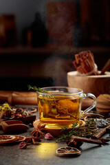 Cup of herbal tea with ingredients on the kitchen table.