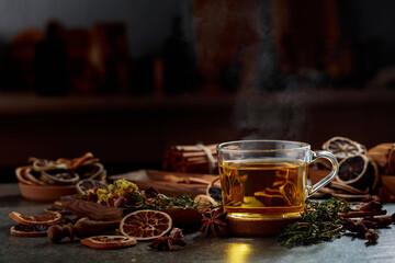 Cup of herbal tea with ingredients on the kitchen table.