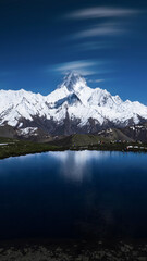 Snowcapped Alpine Mountain Peak Reflected in Pristine Lake with Dramatic Sky