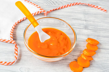 baby food - carrot puree on wooden background