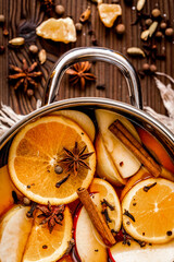 preparation of mulled wine in pot wooden background top view