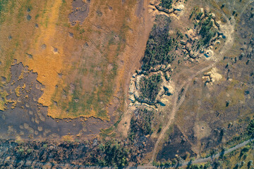Top-down aerial photo showing complex military trenches and earth fortifications in a dry, damaged landscape. Conceptual image of a war zone, defense line, and conflict aftermath.