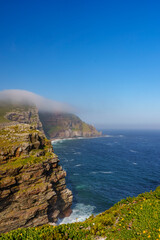 View of Cape Point from the Cape of Good Hope with the upper lighthouse (built in 1859) shrouded in mist, which is why in 1919,  the lower one was built. Cape Town. Western Cape. South Africa.