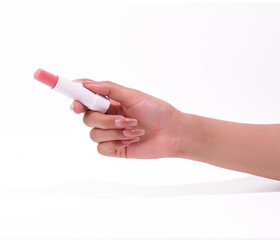 Hand holding a pink lip balm stick on a clean white background, beauty concept.