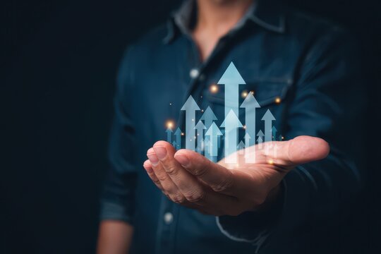 Businessman holding glowing arrows pointing upwards with hand gesture