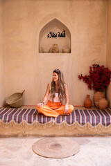 Woman relaxing at bahla fort, oman cultural travel