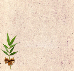 Background with eco paper texture, green leaves, adhesive tape bow. Sustainable development of strategy approach to zero waste, responsible consumption. Reuse, renewable resource, eco-friendly concept