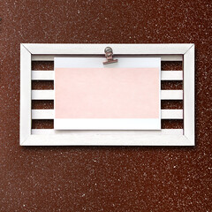 Retro wooden frame with blank paper sheet on stucco wall. Vintage style mood board layout. Vintage wooden empty picture frame on brown wall. Copy space for text