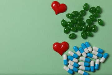 Pills in blister packs on green background with space for text
