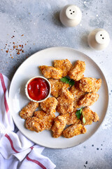 Fresh  homemade crispy chicken nuggets with ketchup on a plate . Top view with copy space.