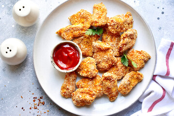 Fresh  homemade crispy chicken nuggets with ketchup on a plate . Top view with copy space.