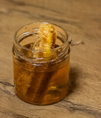 jar of honey with honeycomb on wooden table