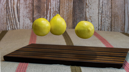 fresh lemons floating above striped wooden board