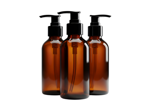 Three amber glass bottles with black pump dispensers against black backdrop