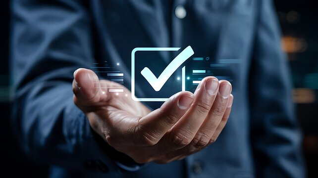 Close up of a businessman s hand holding a glowing digital checkmark inside a square symbolizing completion and success