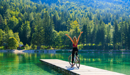 young woman in mountain bike in the nature (lake and forest). active lifestyle concept