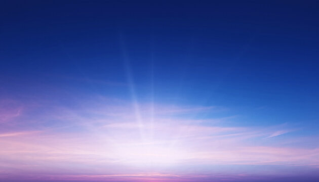 A radiant sunrise emerges with soft pink and purple clouds beneath a deep blue sky, sending gentle rays of light across the horizon