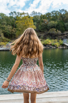 teenager twirling in dress on swim dock on lake
