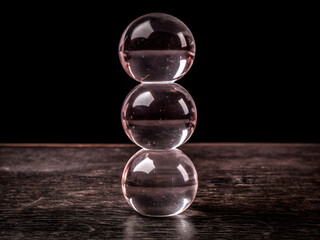 Stacked Glass Spheres Illustration – Transparent Vertical Alignment on Reflective Surface with Minimalist Black Background