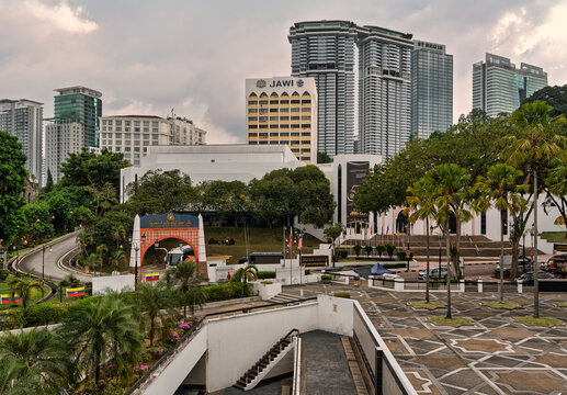 Kuala Lumpur, Malaysia - March 1 2025: Urban landscape, features the JAWI building, St. Regis Kuala Lumpur, and other skyscrapers. Includes an ornate entrance, patterned plaza, and tropical trees