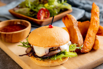 vegetarian mushroom burger, served with thick-cut potato wedges and a side salad toasted bun and features a thick layer of sautéed or caramelized red onions and mushrooms, melted white cheese