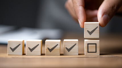 wooden blocks arranged in row with checkmarks, hand placing block above them, symbolizing completed tasks, extra progress, and coordinated teamwork in a positive work or learning environment