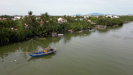 Obraz premium Asia, Vietnam , Hoi An Daily life flows slowly on the Thu Bon River with fishing boats with nets and trawlers - Hoi An the city of lanterns, a UNESCO World Heritage Site