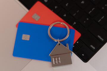 Credit cards and house on laptop keyboard. Online shopping, smart home