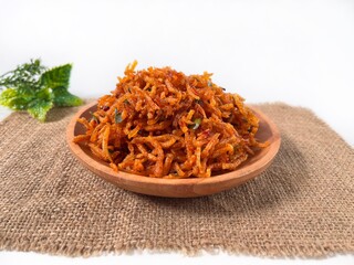 Kentang Mustofa, Indonesian crispy and spicy potato sticks served on a wooden plate on burlap.