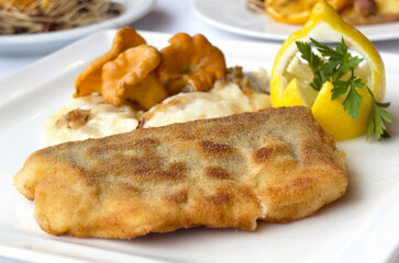 Christmas fried fish in breadcrumbs with chanterelle mushrooms and dumplings