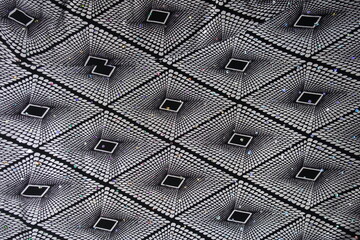 Texture of black and white fabric with geometric pattern and sequins