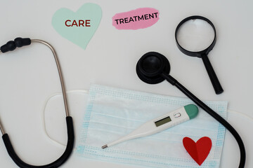 Care and Treatment Concept with Heart Cutout and Medical Tools on Clean Background