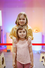 Kids posing for a picture with colorful background lights