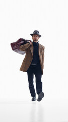 Confident businessman walking with large travel bag in classic outfit. Concept of corporate mobility visuals, travel advertising, professional lifestyle design, business promotions.